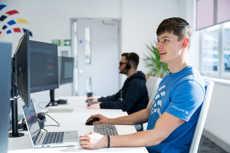 Brenden and Liam at their desks, focusing on their computer screens in the Breakwater office.