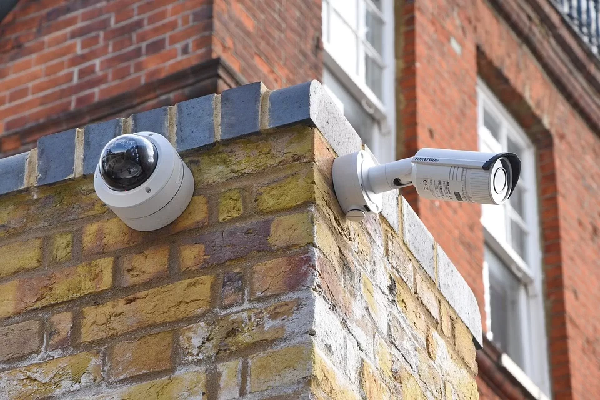 Two CCTV cameras on brick wall