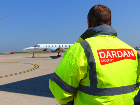 Man stood looking at plan with high-vis jacket on and Dardan Logo on the back