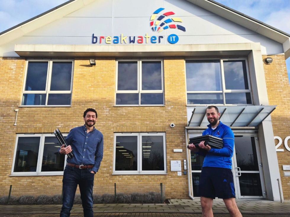 John Gostling, MD with Norwich School Staff outside Breakwater Office holding laptops