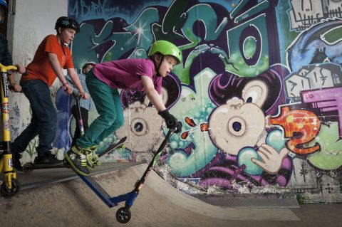 Kids on scooters at skate park