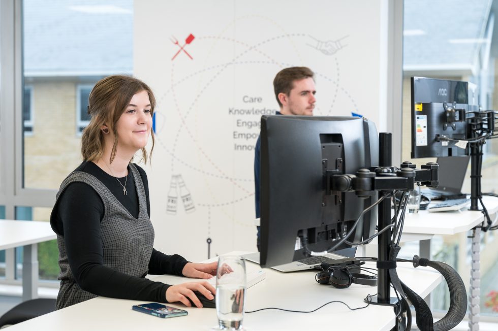 Sam working at standing desk in the Breakwater office