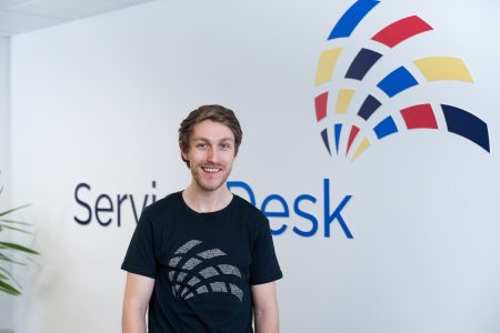 Leon in front of a Service Desk Sign