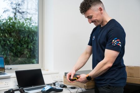 A man using a screwdriver, concentrating on his task in a bright workspace.