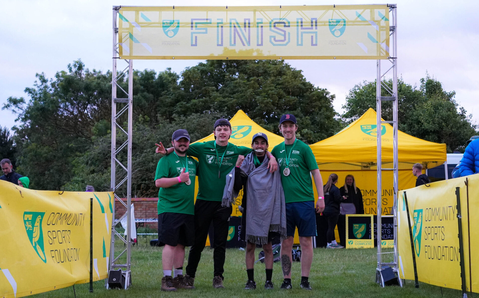 Liam, Brenden, Aqeel and Leon a the finish line branded with Community Sports Foundation